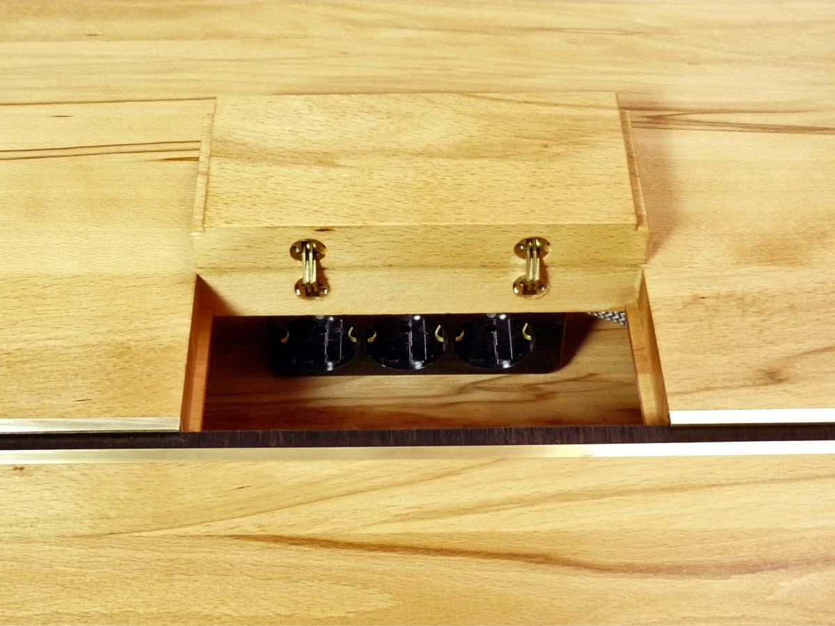 Elektrifizierter Schreibtisch in Kernbuche: Die Klappe führt zur integrierten Steckdose (© Tischlerei Andreas Degner)